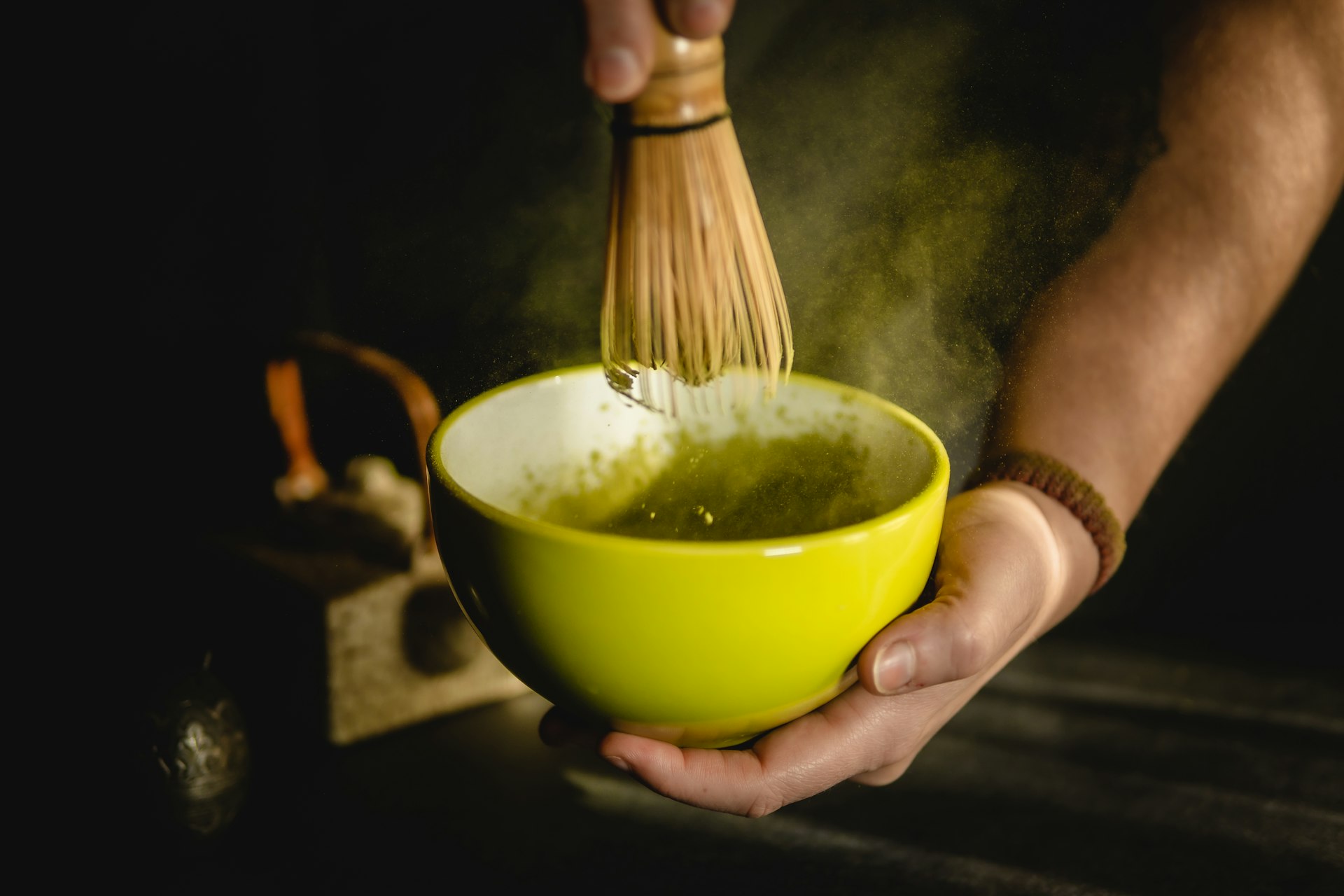 person holding green ceramic bowl